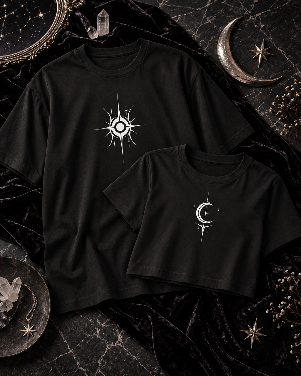 A black tee with a white sun graphic beside a black cropped top with a white crescent and star.